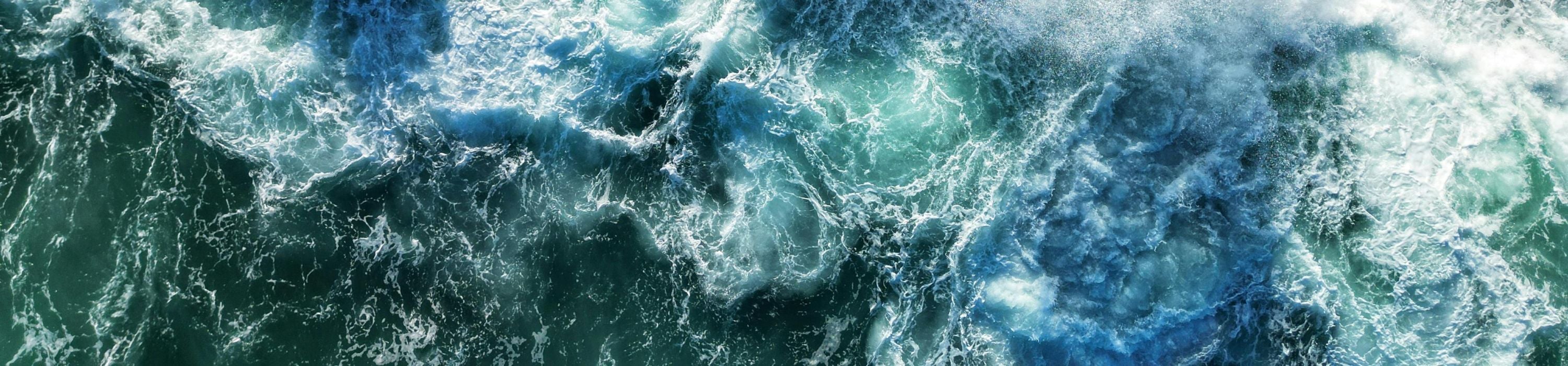 Close-up of turbulent water with swirling blue and green colors